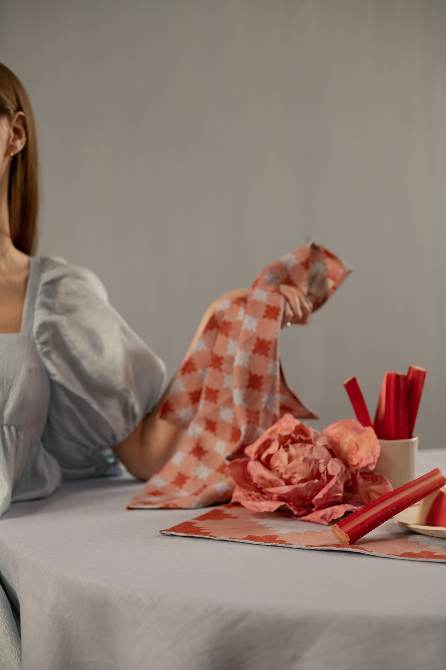 Woman holding blue and red napkin at a table with decorations